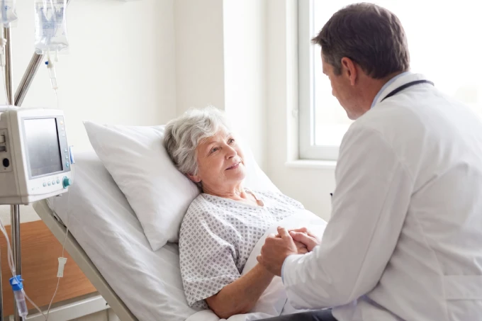 Doctor supporting an elderly patient in a hospital
